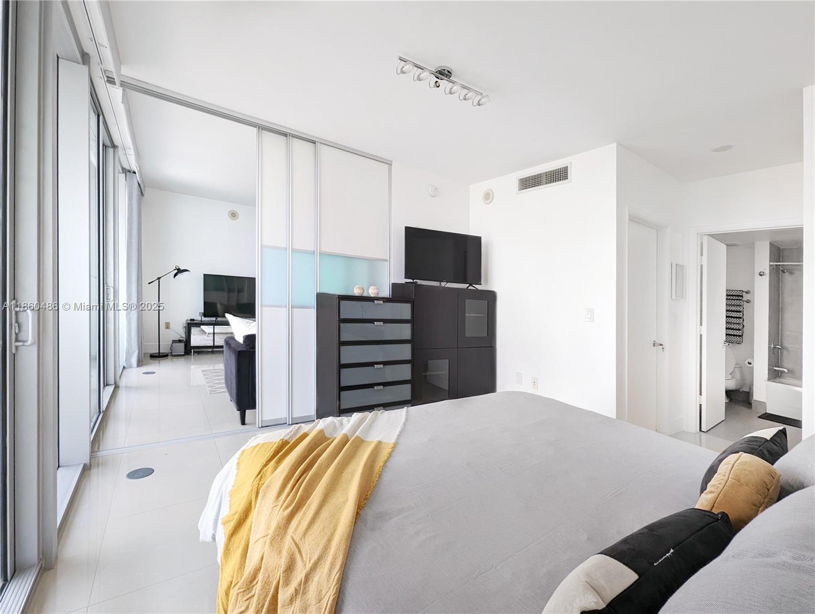 92 Southwest 3rd Street, Unit 1908 Miami, FL 33130 - Photo 8 of 18 a bedroom with a bed and dresser