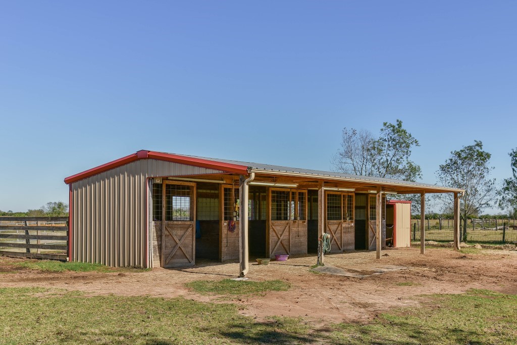 34366 Owens Road Hempstead, TX 77445 - Photo 44 of 46 Multi-purpose barn with a covered porch provides excellent space for livestock, equipment, storage, or ranch operations while complementing the property's country setting.