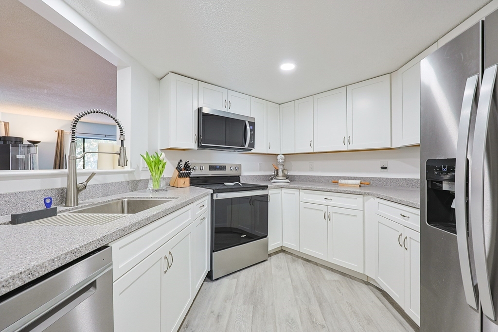 276 Trailside Way, Unit 276 Ashland, MA 01721 - Photo 3 of 32 a kitchen with cabinets stainless steel appliances and a sink
