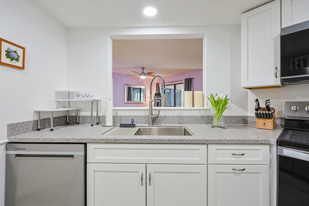 276 Trailside Way, Unit 276 Ashland, MA 01721 - Photo 4 of 32 a kitchen with kitchen island granite countertop a sink a stove and cabinets
