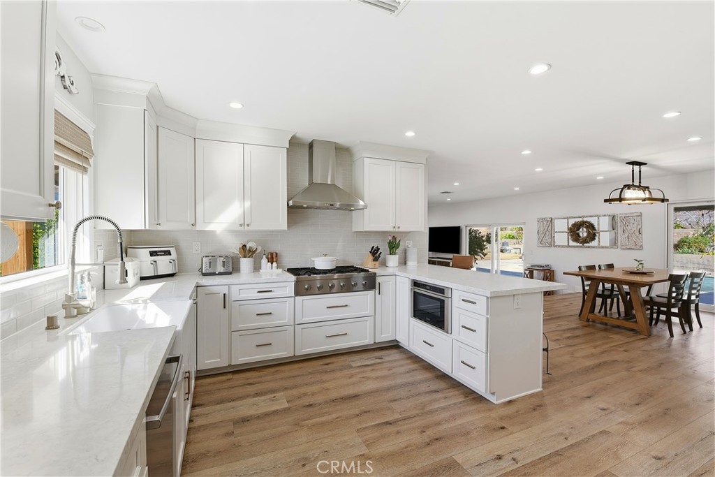 10560 Limerick Avenue Chatsworth, CA 91311 - Photo 11 of 43 a kitchen with stainless steel appliances white cabinets a sink and a stove