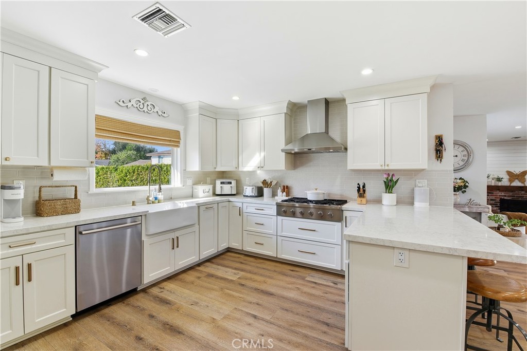 10560 Limerick Avenue Chatsworth, CA 91311 - Photo 13 of 43 a kitchen with white cabinets appliances a sink and a window