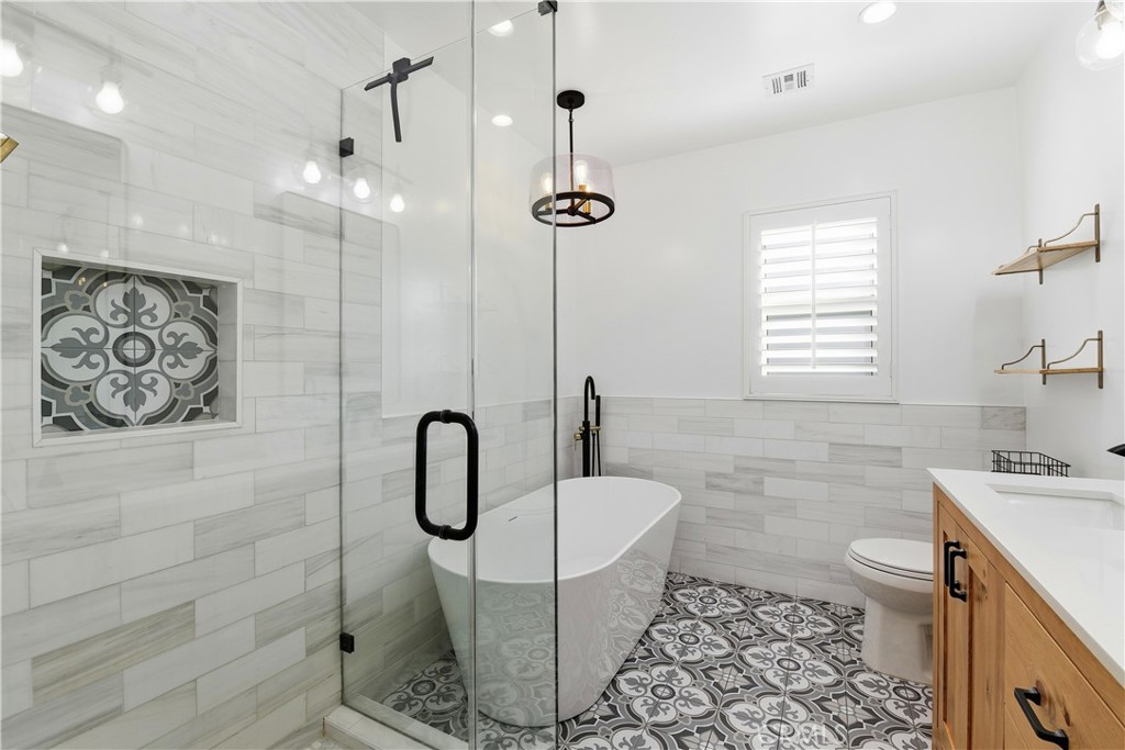 10560 Limerick Avenue Chatsworth, CA 91311 - Photo 30 of 43 a bathroom with a granite countertop sink a toilet and shower