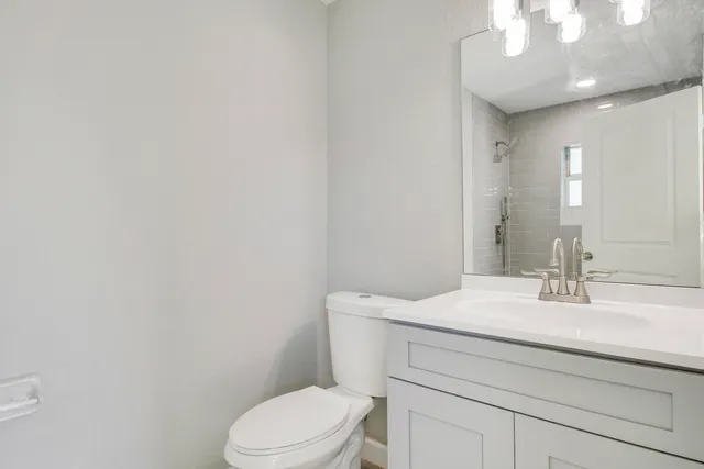 a bathroom with a sink a toilet and mirror