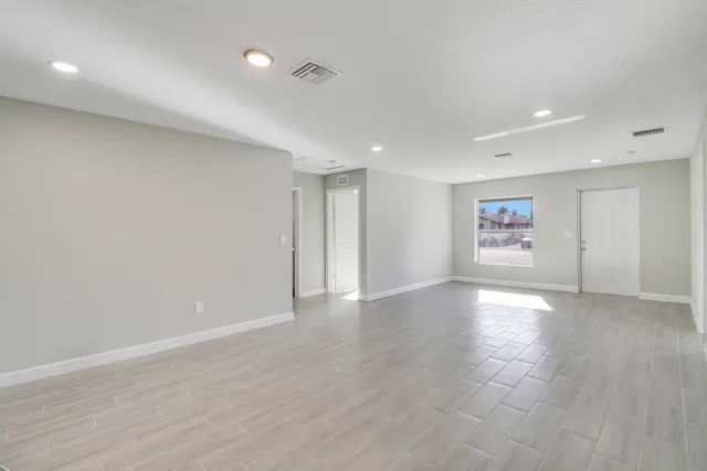 a view of an empty room with wooden floor
