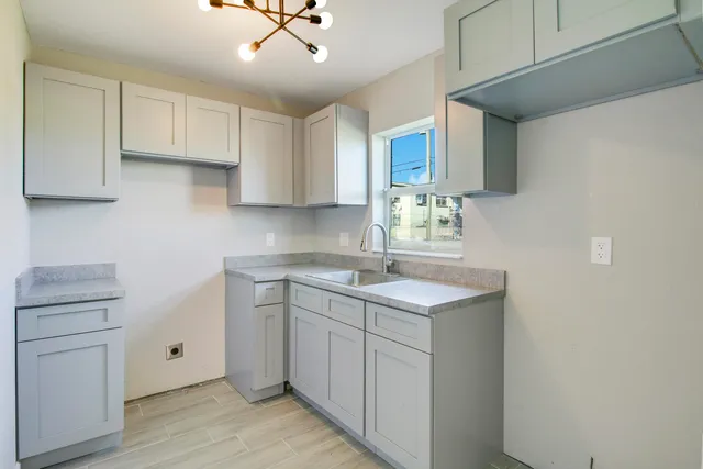 a kitchen with a sink cabinets and wooden floor