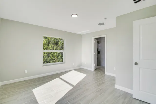 an empty room with wooden floor and a window