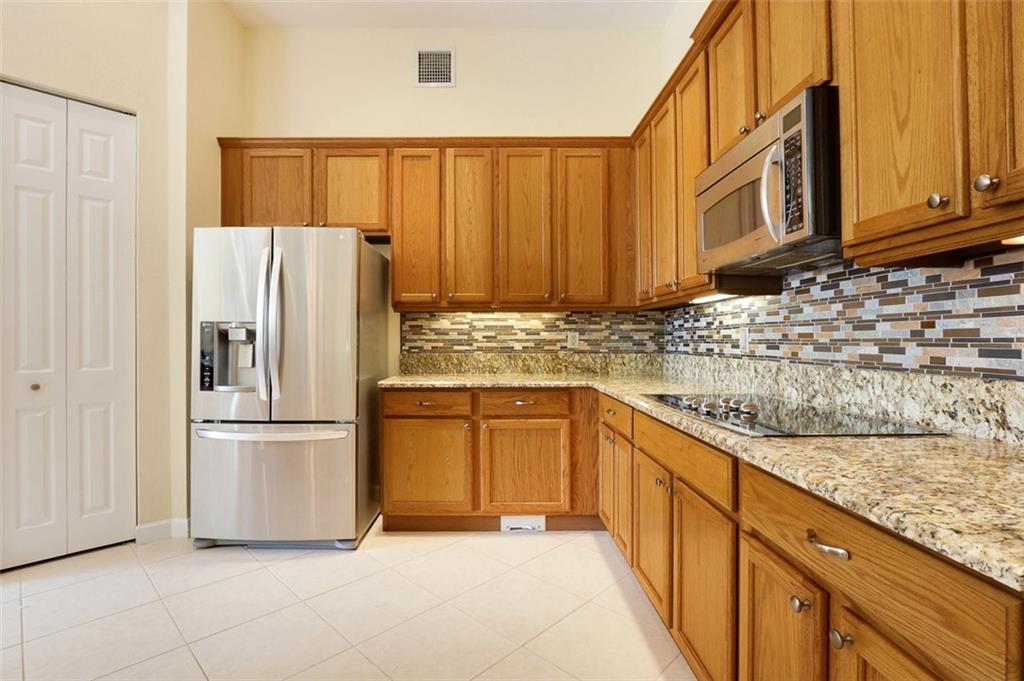 767 Southwest River Bend Circle Stuart, FL 34997 - Photo 11 of 36 a kitchen with granite countertop a refrigerator and a sink