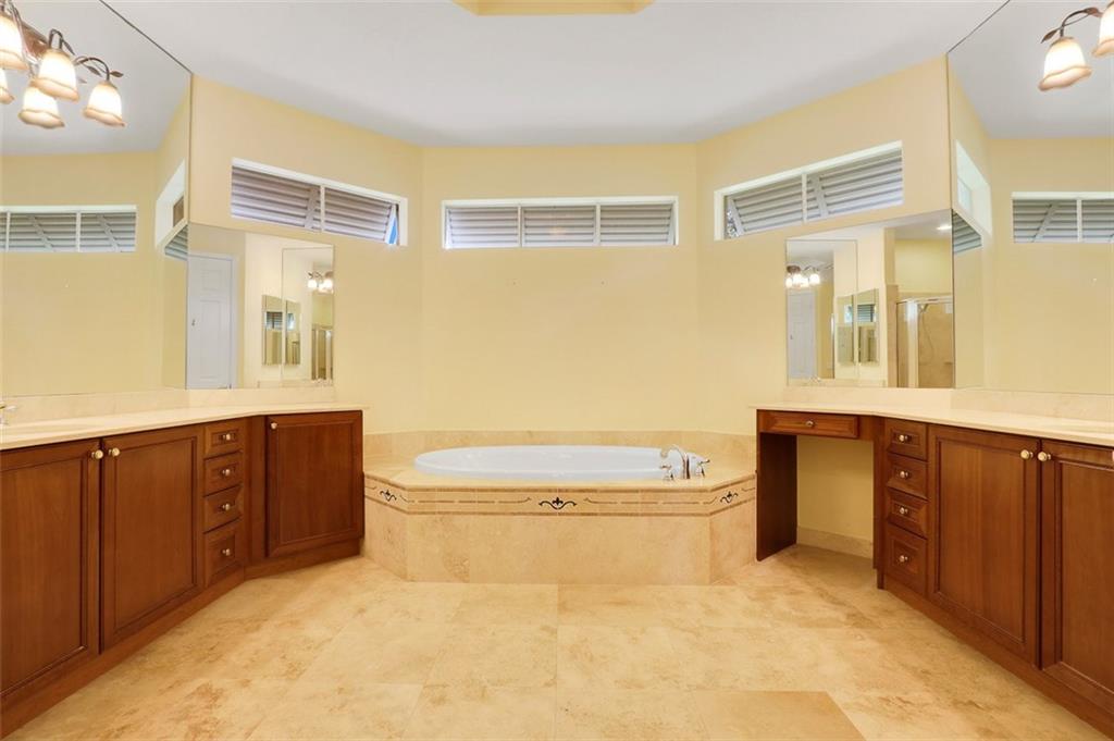 767 Southwest River Bend Circle Stuart, FL 34997 - Photo 23 of 36 a bathroom with a granite countertop toilet sink and mirror
