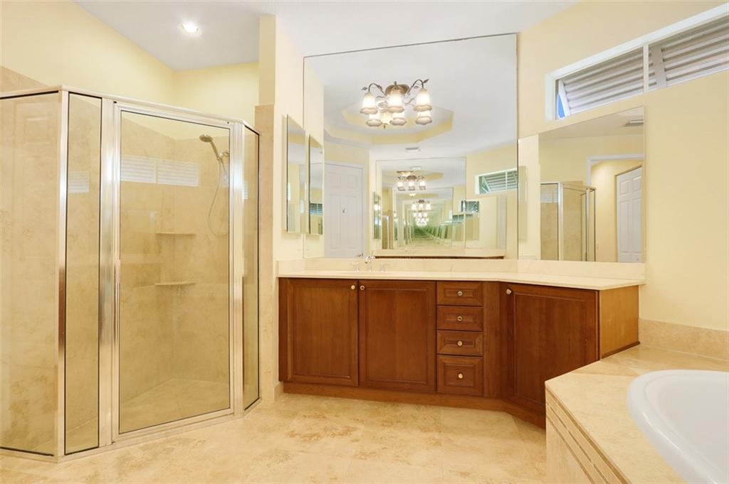 767 Southwest River Bend Circle Stuart, FL 34997 - Photo 24 of 36 a bathroom with a double vanity sink a large mirror and a bathtub