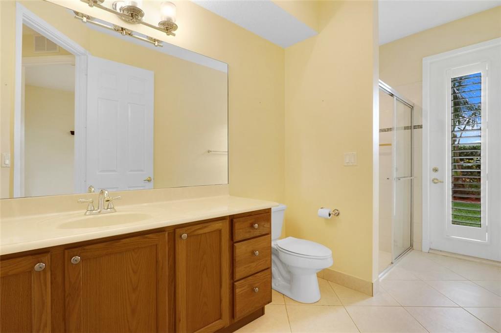 767 Southwest River Bend Circle Stuart, FL 34997 - Photo 27 of 36 a bathroom with a granite countertop sink a toilet and a mirror