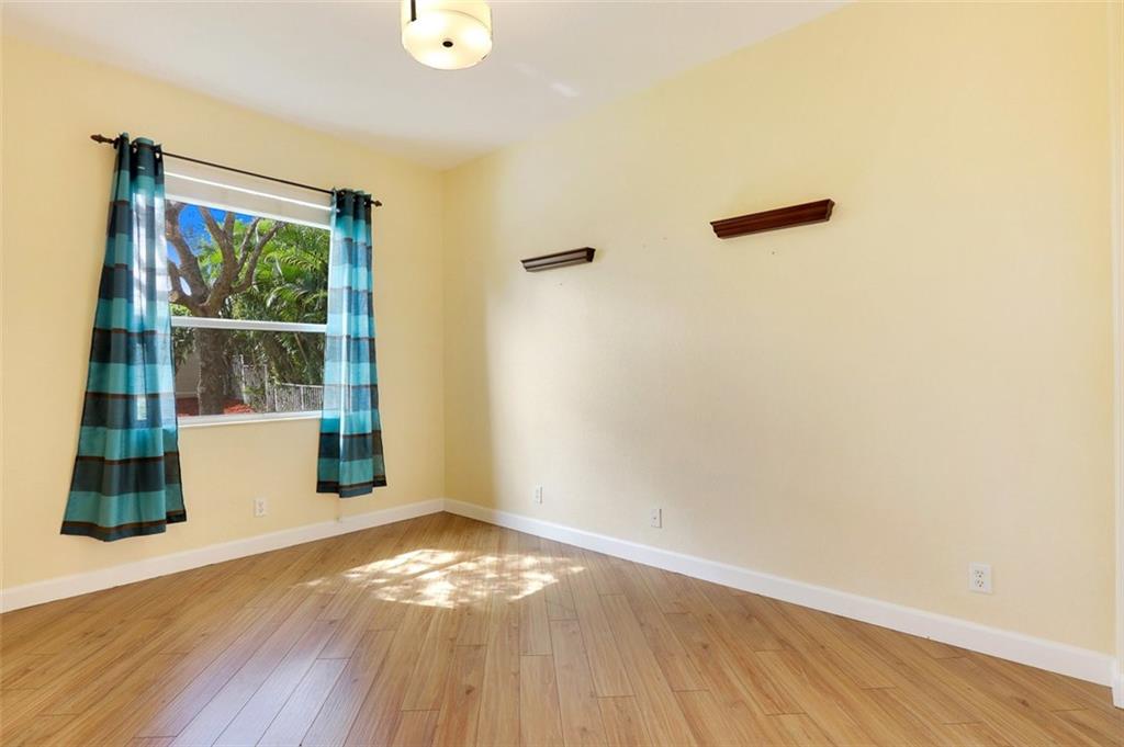 767 Southwest River Bend Circle Stuart, FL 34997 - Photo 28 of 36 a view of an empty room with wooden floor and a window