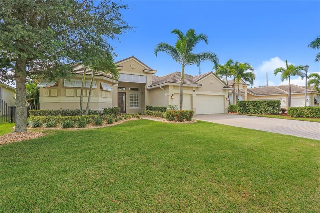 767 Southwest River Bend Circle Stuart, FL 34997 - Photo 6 of 36 a front view of a house with a garden and yard