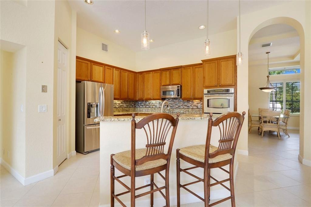 767 Southwest River Bend Circle Stuart, FL 34997 - Photo 10 of 36 a kitchen with stainless steel appliances granite countertop a refrigerator and a stove top oven