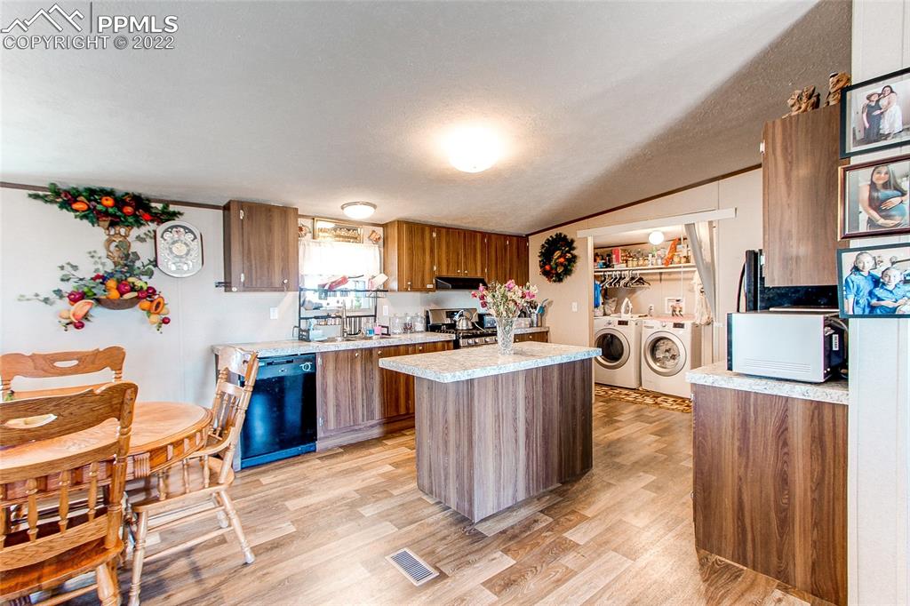 5955 Mulberry Road Calhan, CO 80808 - Photo 4 of 25 a kitchen with stainless steel appliances granite countertop a refrigerator a sink dishwasher and a stove with wooden cabinets