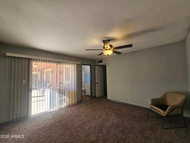 a view of a livingroom with a ceiling fan and window