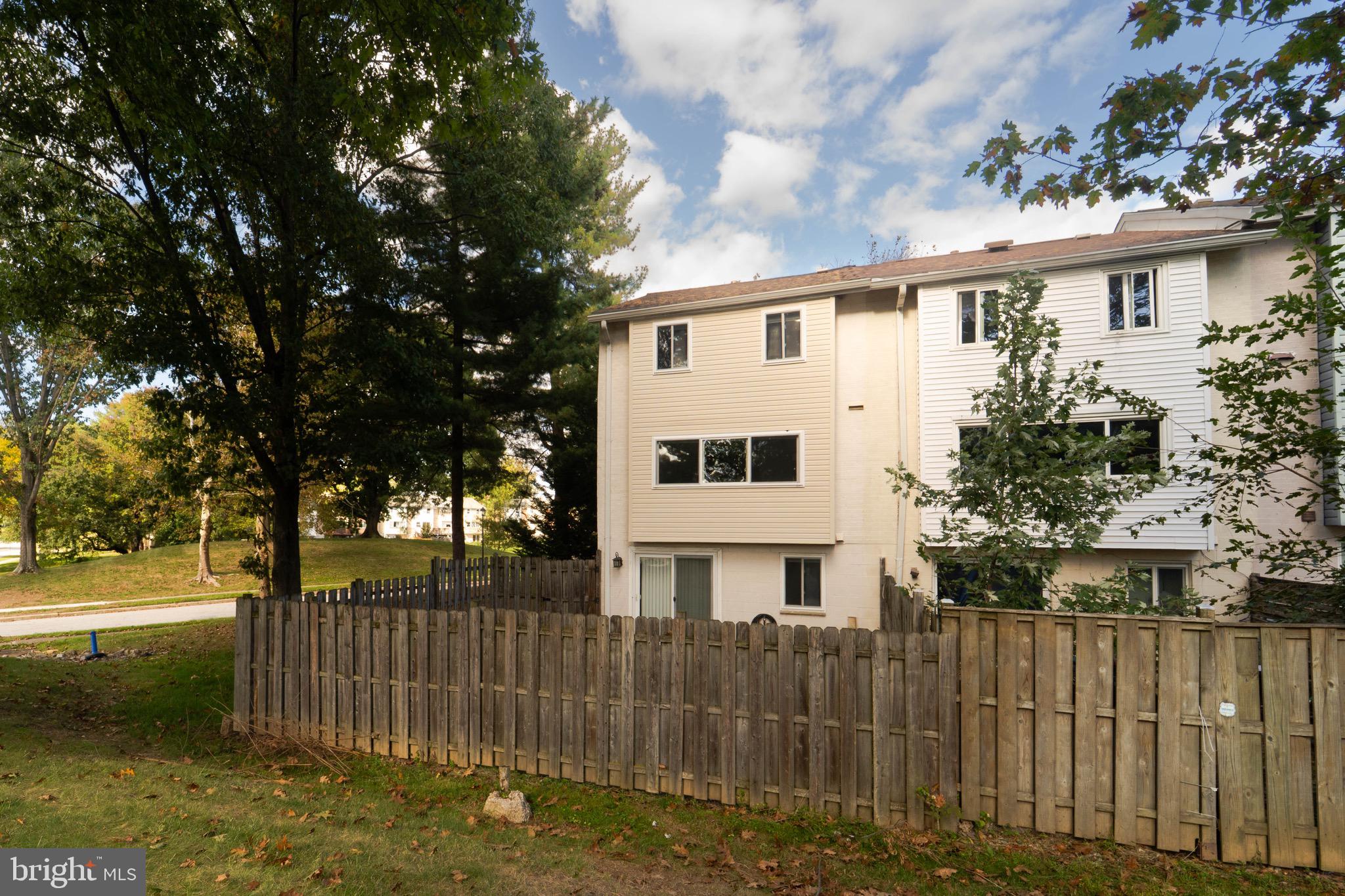 9318 Matador Road Columbia, MD 21045 - Photo 32 of 32 a view of a white house with a small yard and wooden fence