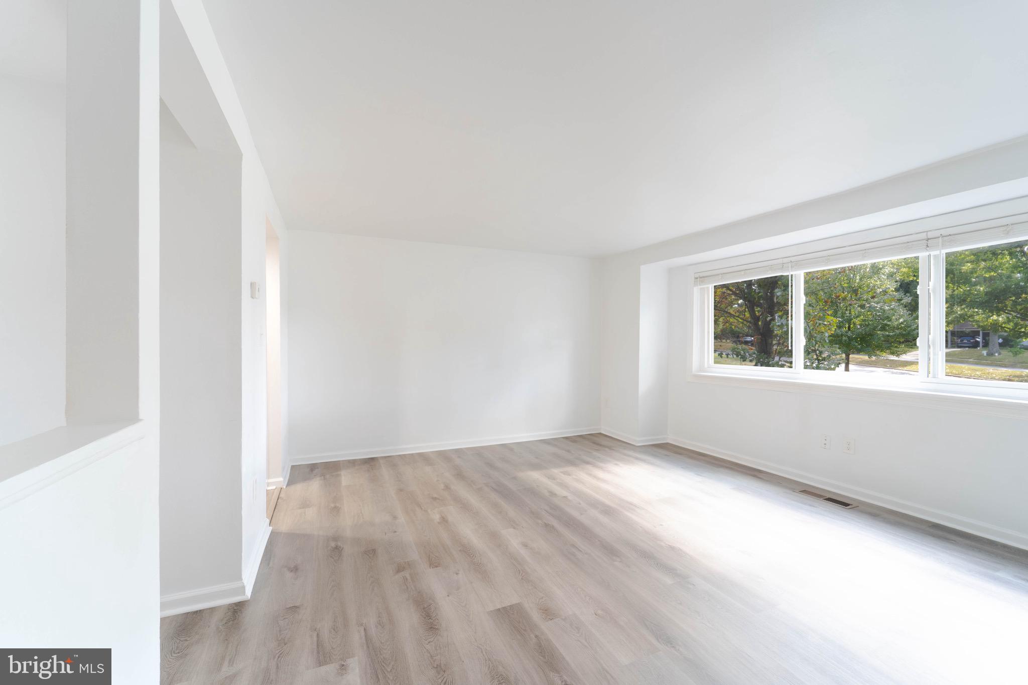 9318 Matador Road Columbia, MD 21045 - Photo 4 of 32 an empty room with wooden floor and windows