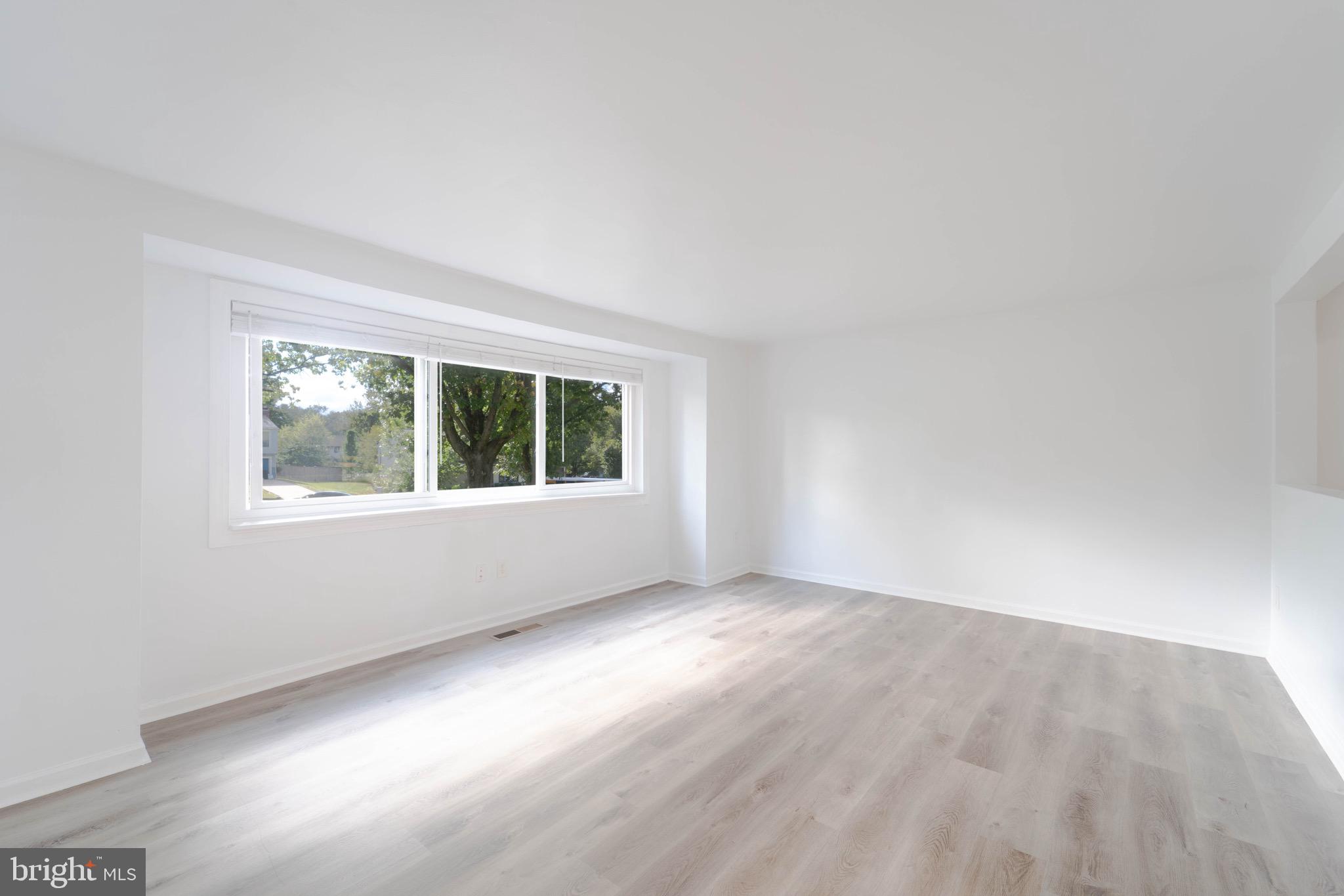 9318 Matador Road Columbia, MD 21045 - Photo 7 of 32 an empty room with wooden floor and windows