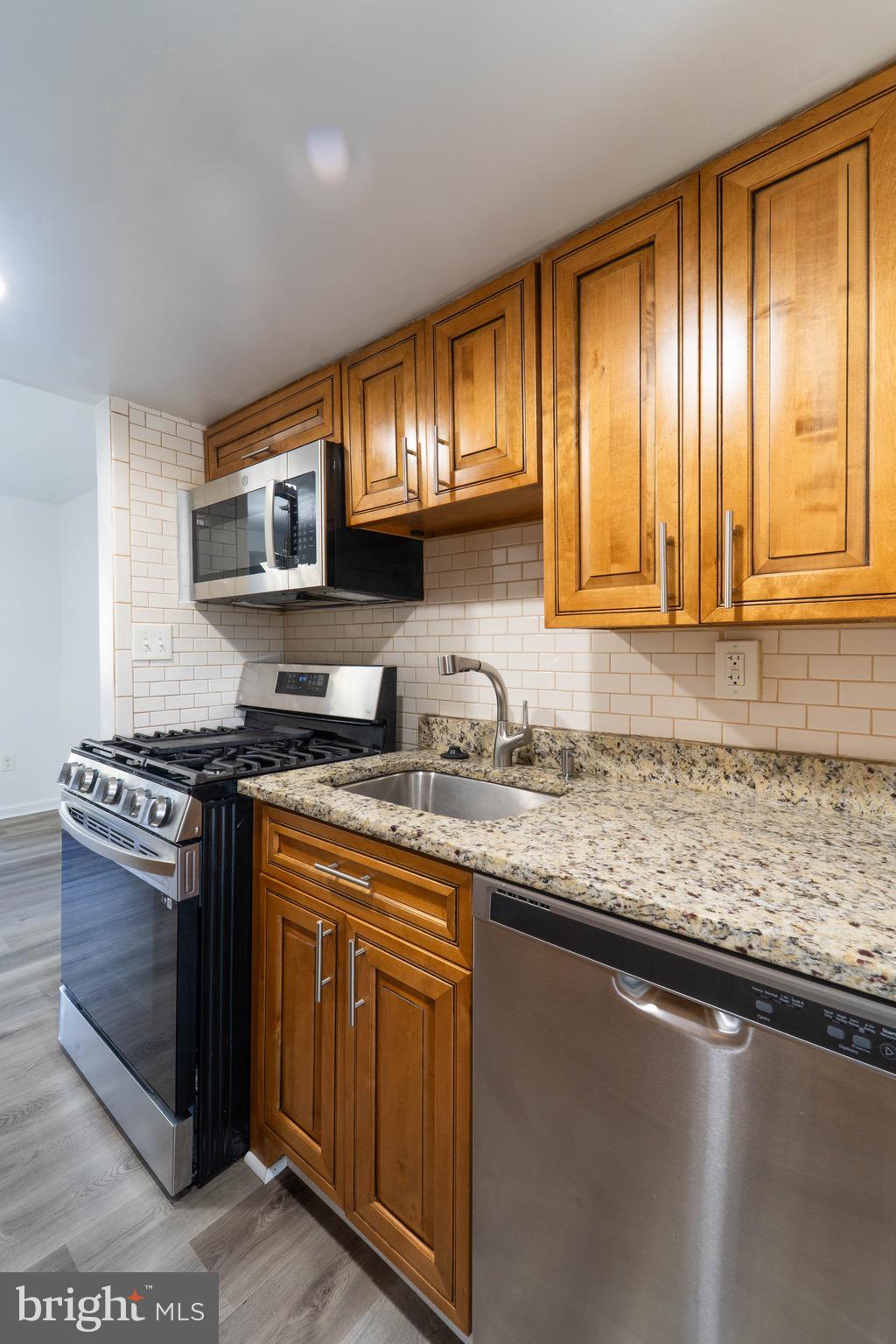 9318 Matador Road Columbia, MD 21045 - Photo 9 of 32 a kitchen with stainless steel appliances granite countertop a stove a sink and a microwave