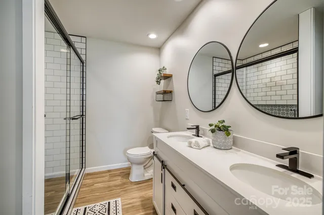 a bathroom with a granite countertop toilet a sink and a mirror