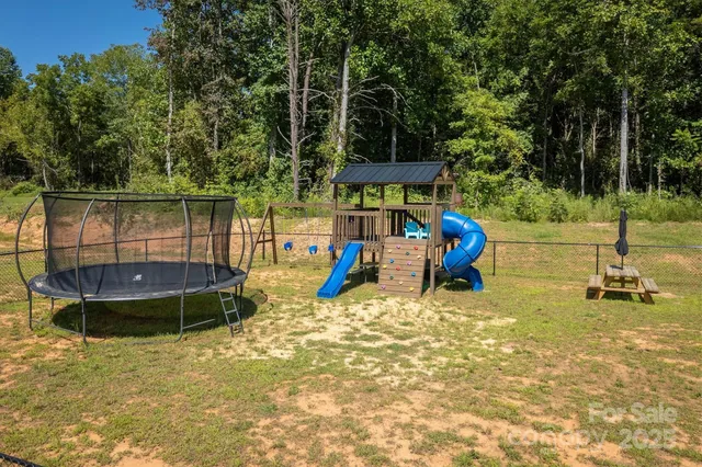 a view of a swimming pool with a patio and a yard
