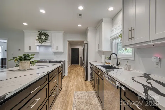 a kitchen with stainless steel appliances a sink stove and cabinets