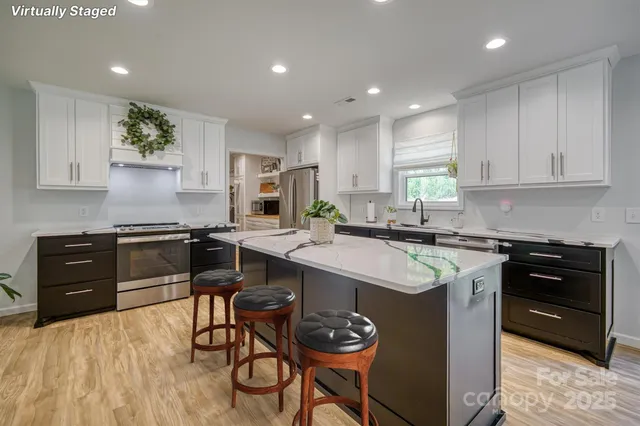 a kitchen with a stove a sink a dining table and chairs