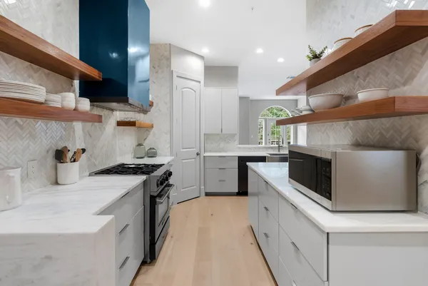 a kitchen with stainless steel appliances granite countertop a stove a sink and a refrigerator