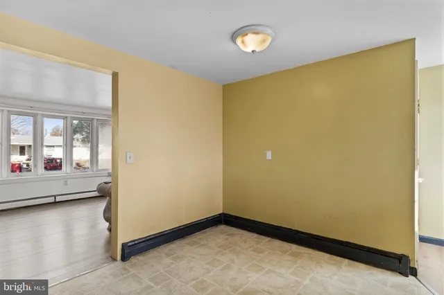 an empty room with a window and ceiling fan