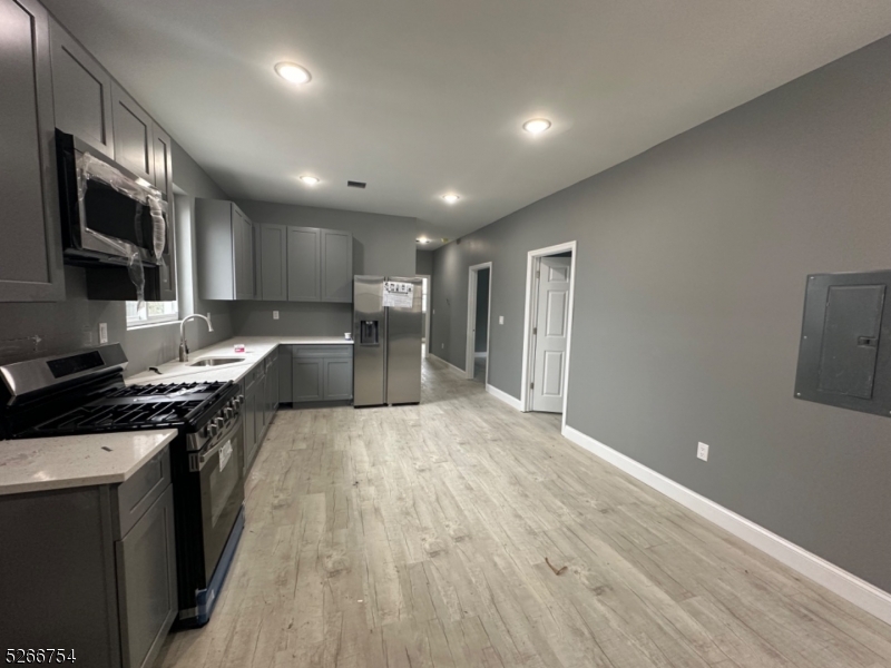 16 Robert Street Paterson, NJ 07503 - Photo 3 of 9 a kitchen with granite countertop a stove and a wooden floor