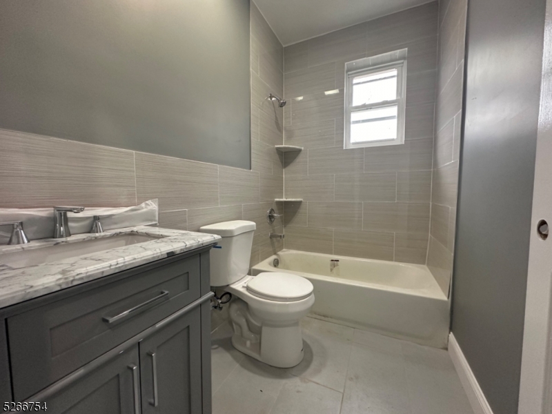 16 Robert Street Paterson, NJ 07503 - Photo 5 of 9 a bathroom with a granite countertop toilet a sink and bathtub