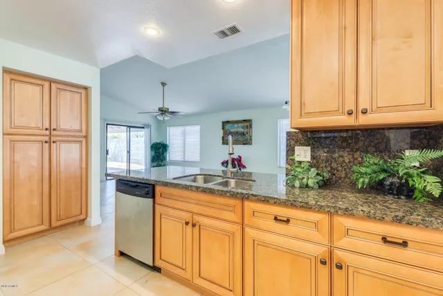a kitchen with white cabinets and chandelier