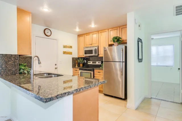 a kitchen with granite countertop a refrigerator and a sink