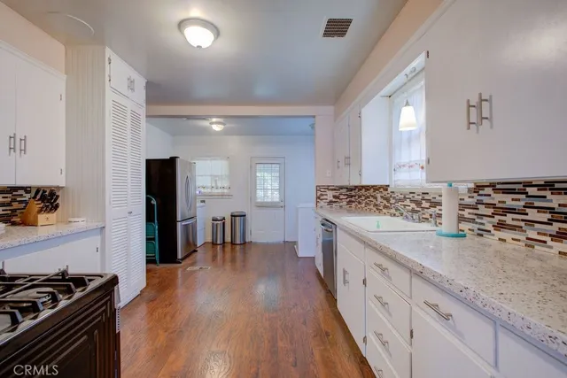 a kitchen with sink stove and refrigerator