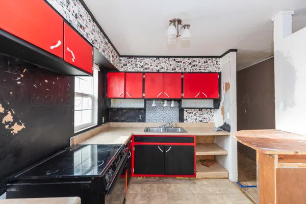 a utility room with stainless steel appliances granite countertop a stove a sink and a microwave