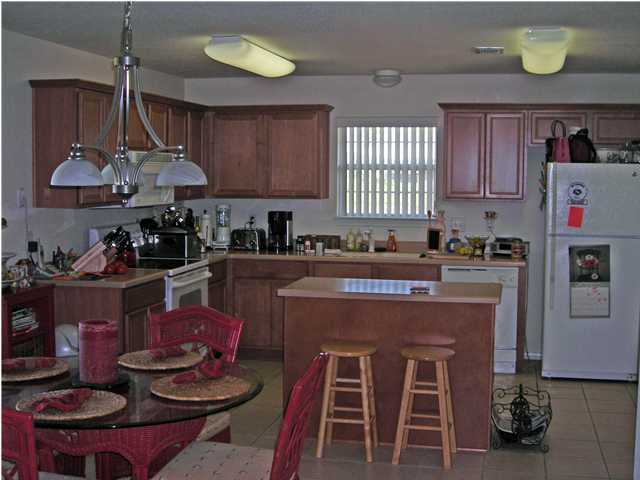 437 Shipwreck Road Santa Rosa Beach, FL 32459 - Photo 3 of 6 a kitchen with stainless steel appliances granite countertop a stove a sink and a refrigerator