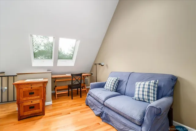 a view of a workspace with furniture and a window