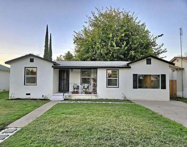 a front view of house with a garden and yard