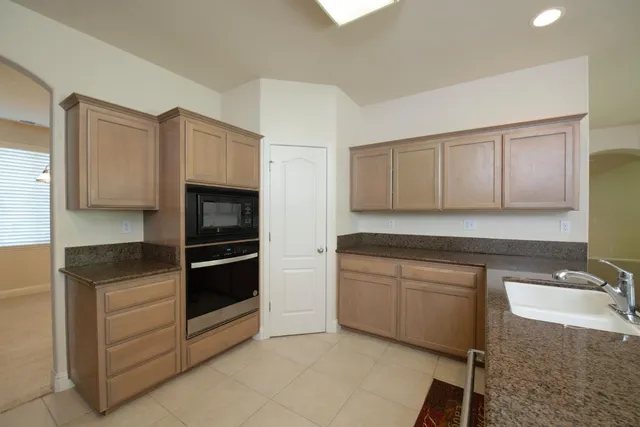 a kitchen with granite countertop white cabinets and stainless steel appliances