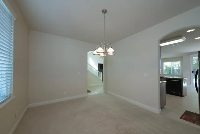 a view of a chandelier in big room and kitchen