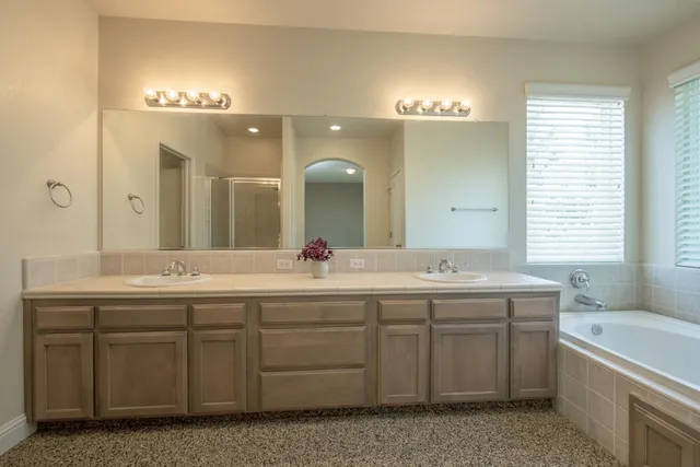 a bathroom with a double vanity sink a toilet and a mirror