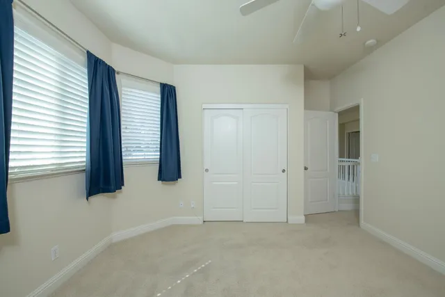 an empty room with windows and fan