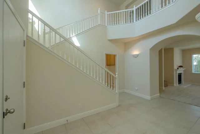 a view of staircase with railing and white walls