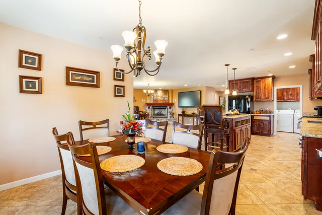 a view of a dining room with furniture a kitchen and chandelier