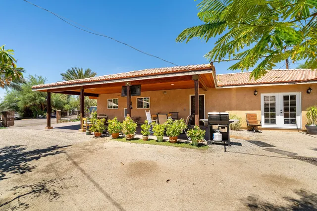 a view of a patio with a table and chairs under an umbrella