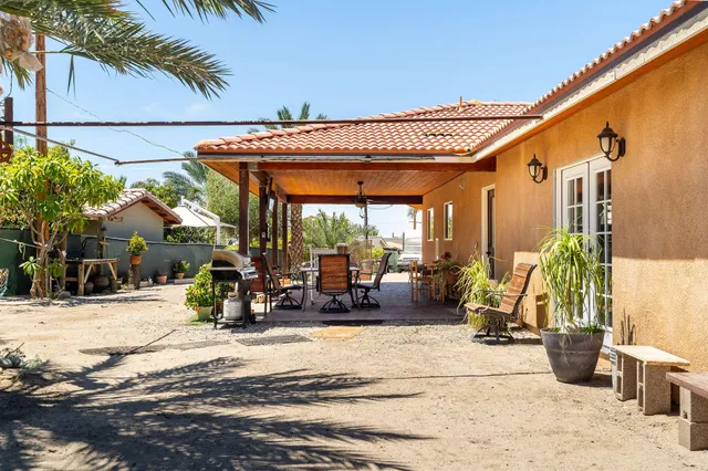 a view of a patio with a dining table and chairs under an umbrella