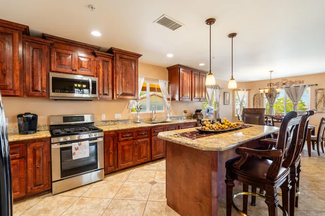 a kitchen with stainless steel appliances granite countertop a stove sink microwave and cabinets