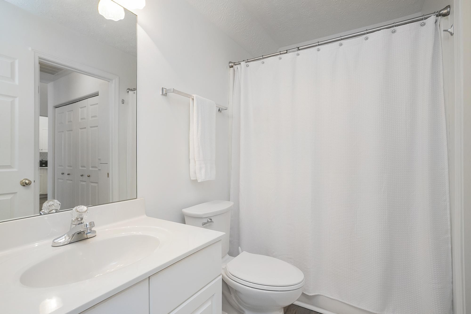 3911 Dodson Chapel Road, Unit 32 Hermitage, TN 37076 - Photo 11 of 25 a bathroom with a sink a toilet and shower curtain