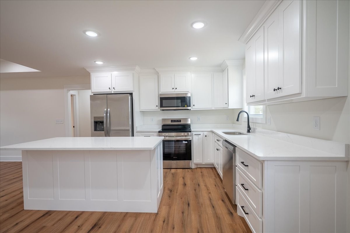 3987 Buffalo Road Summertown, TN 38483 - Photo 10 of 26 a kitchen with stainless steel appliances granite countertop a stove top oven a sink dishwasher and a refrigerator with wooden floor